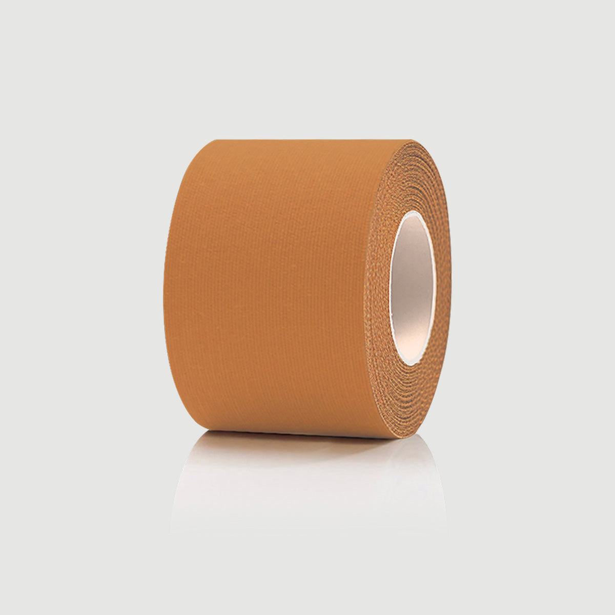 Roll of brown kinesiology tape on a light gray background