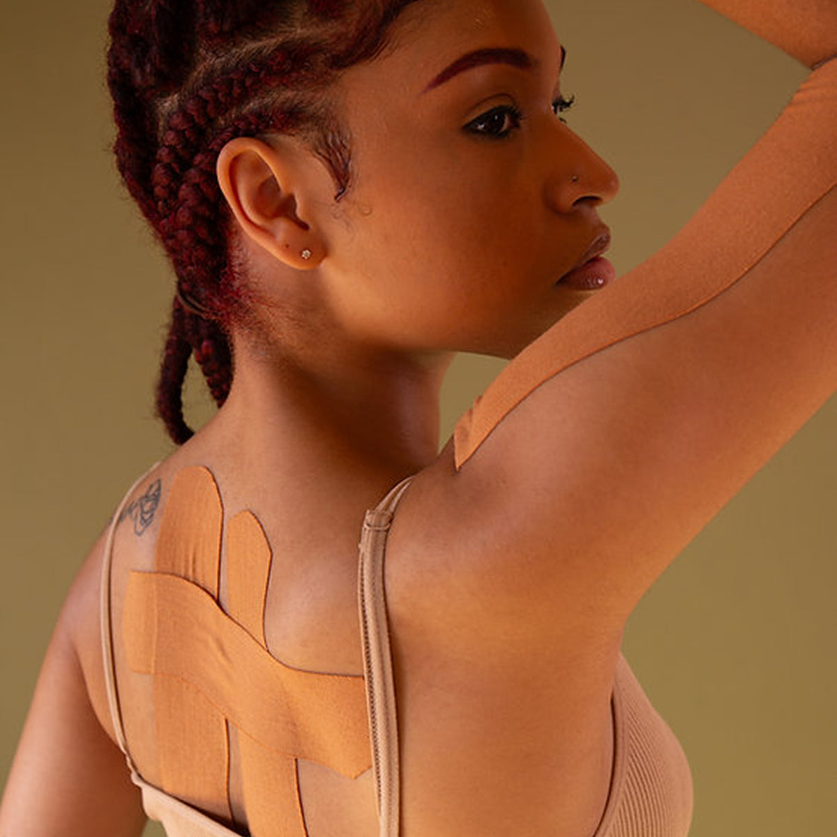 Woman wearing a brown leather outfit with cut-out design on a beige background