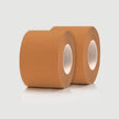 Two rolls of brown tape on a light gray background