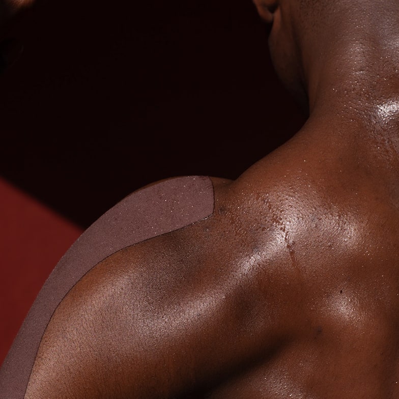 Close-up of a muscular person's back with a dark background